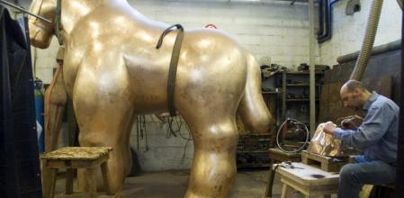 Un operario de la fundición Mariani da los últimos retoques a una escultura de Botero antes de la exposición que hubo este verano