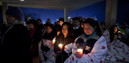 Vecinos de Newtown, en Connecticut, sostienen velas en una vigilia frente a la escuela donde un joven mató a 26 personas y luego a sí mismo