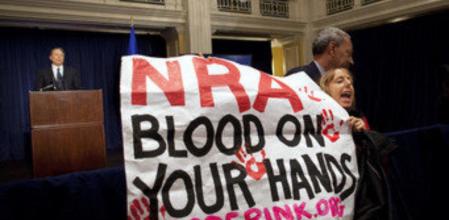 Una mujer despliega una pancarta en la que se puede leer