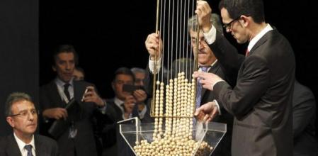 Lotería de Navidad: Momento en el que las bolas caen en una tolva, un gran embudo transparente, desde la que se volcarán en los bombos, momentos antes de comenzar el Sorteo Extraordinario de Navidad