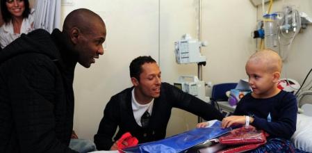 Eric Abidal y Adriano dan un regalo al pequeño Ander durante la visita de los futbolistas azulgrana al Hospital de la Vall d'Hebron