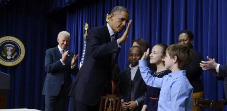 El presidente estadounidense Barack Obama saluda a un niño tras firmar 23 órdenes ejecutivas para endurecer el control de armas junto al vicepresidente Joe Biden en Washington, Estados Unidos el 16 de enero de 2013