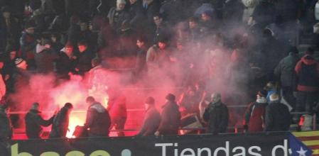 Imagen de un grupo de aficionados manipulando una bengala dentro del Camp Nou