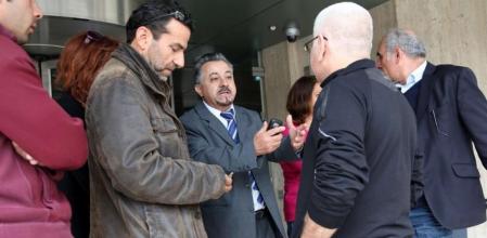 Un empleado de banca de explicaciones a clientes frente a una oficina de Nicosia.