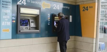 Un hombre retira dinero del cajero de una sucursal bancaria