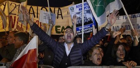 Varios manifestantes protestan y muestran pancartas durante una concentración contra el impuesto sobre los depósitos, frente al Parlamento de Chipre, en Nicosia.