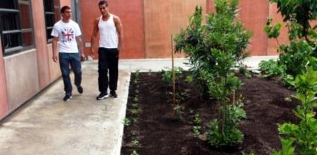 Dos internos pasean ante el huerto ecológico de Lledoners, la prisión tranquila que ensaya un modelo basado en la convivencia