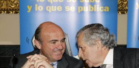 El ministro de Economía, Luis de Guindos, junto al periodista Miguel Ángel Aguilar durante su asistencia al almuerzo organizado por la Asociación de Periodistas Europeos en Madrid