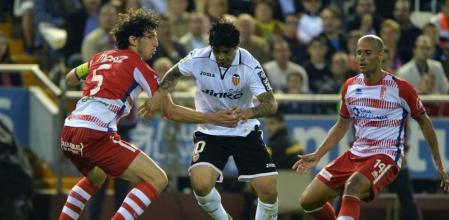 Ever Banega pelea por un balón ante jugadores del Granada