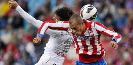 El delantero del Mallorca, Víctor Casadesús, salta con el defensa brasileño Joao Miranda, del Atlético de Madrid