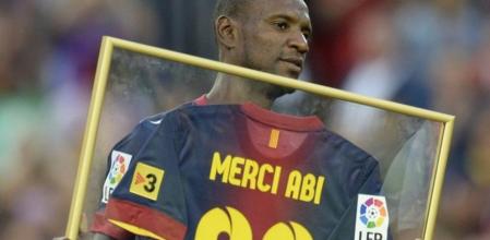 Abidal muestra al público del Camp Nou la camiseta que le han firmado sus compañeros