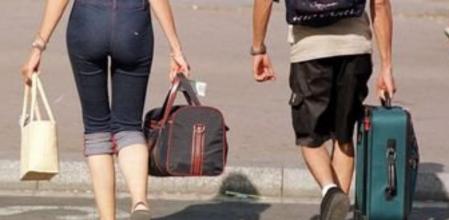 Una pareja de viajeros cargan con el equipaje