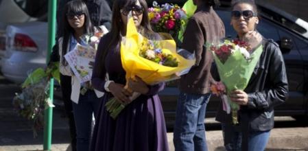 La nieta de Nelson Mandela, Ndileka Mandela, acude al hospital junto a otros familiares con ramos de flores dejados por los ciudadanos que esperan noticias del expresidente Sudafricano
