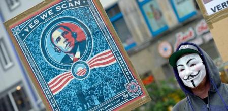 Un manifestante protesta contra el escándalo generado por el programa de espionaje de EE.UU. con una pancarta en la que aparece Obama bajo el lema 'Yes we scan'