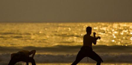 Práctica de taichi en una playa