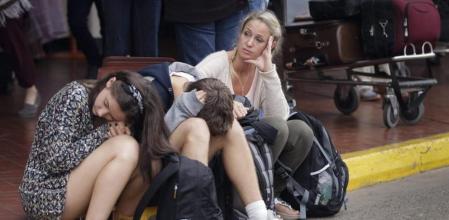 Varios pasajeros esperan su vuelo a las puertas del aeropuerto
