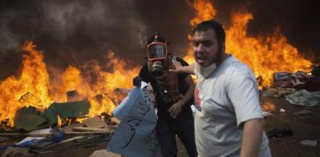 Un partidario del depuesto presidente de Egipto Mohamed Morsi huye de las fuerzas de seguridad del Gobierno interino, que ordenó el desalojo de las acampadas de los Hermanos Musulmanes