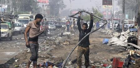 Varias personas intentan recuperar enseres entre las ruinas tras la expulsión de los manifestantes de la plaza Rabea al Adauiya en El Cairo