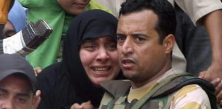 Una mujer es escoltada por las fuerzas de seguridad a las puertas de la mezquita de Al-Fatah, rodeada de manifestantes anti-Morsi