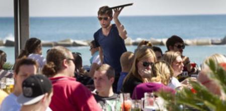 Turistas en un chiringuito de playa en Barcelona
