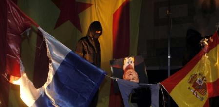 Unos encapuchados queman las banderas de Francia, Unión Europea y una foto del Rey Juan Carlos durante la Diada
