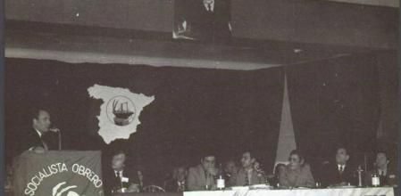 Presidencia del XXVI Congreso del PSOE, (XIII en el exilio), celebrado en Suresnes. François Mitterrand, secretario del PSF interviene en el estrado. Sentados, de izda a dcha: Ronald Balcomb, secretario de la Internacional Socialista, José Martínez Cobos, Alfonso Guerra, Manuel Garnacho y Fabián Ramón. Octubre de 1974