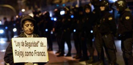 Una manifestante ante varios policías en la protesta de Madrid