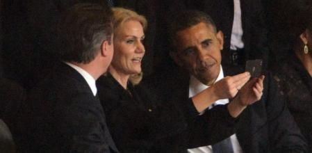 La primera ministra danesa, en un instante de la ceremonia en Soweto, ha sacado su teléfono móvil y, al parecer, ha pedido a Obama y al primer ministro británico, David Cameron, si podía sacarse una foto con ellos.