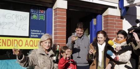 La lotera Maria Luisa (i) celebra con una familia agraciada con el Gordo de Navidad, el 62.246, a la entrada su administración, número 8 de Leganés, que ha repartido hoy 360 millones de euros de ese primer premio, dotado con cuatro millones de euros por serie (400.000 euros por décimo) en el sorteo extraordinario de la Lotería de Navidad. EFE/Zipi