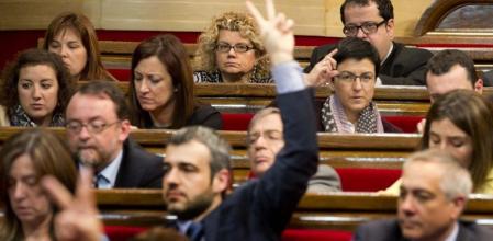 El portavoz del grupo parlamentario del PSC, Maurici Lucena, indica a sus diputados el sentido de su voto tras el debate de presupuestos para 2014. En segundo plano, los tres diputados socialistas considerados disidentes.