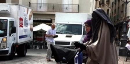 Una mujer vestida con niqab, paseando por la plaza Mercadal de Reus, en julio de 2013