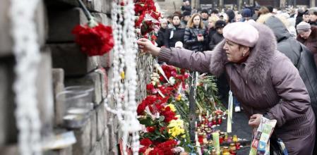 Una mujer recordando a los fallecidos en las protestas en la plaza de la Independencia de Kíev que han acabado con Yanukóvich
