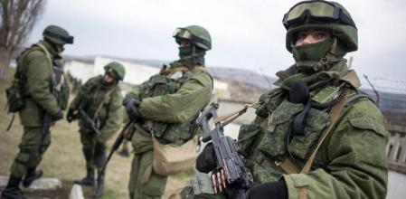 Hombres armados con uniforme sin identificación hacen guardia frente a un cuartel del ejército ucraniano en las afueras de Simferopol