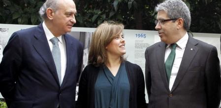 La vicepresidenta del Gobierno, Soraya Sáenz de Santamaría (c); el ministro del Interior, Jorge Fernández Díaz (i), y el conseller de Presidencia de la Generalitat, Francesc Homs (d), durante la inaguración de de la exposición 'EFE, 75 años en fotos'