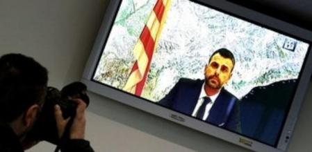 Un informador gráfico fotografía un monitor en la sala de prensa de la Audiencia Nacional durante la declaración por videoconferencia del conseller de Territorio, Santi Vila, que testificó en la cuarta jornada del juicio contra 19 acusados del asedioalParlament en 2011.