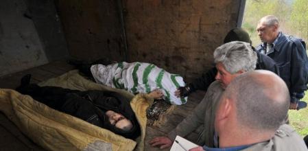 Policías ucranianos examinan los cuerpos de los milicianos prorrusos muertos en un control en el este de Ucrania