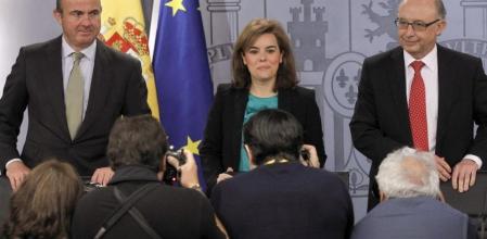 La vicepresidenta del Gobierno, Soraya Saéz de Santamaría,c, acompañada por los ministros de Economía, Luis de Guindos,iz., y de Hacienda, Cristóbal Montoro, poco antes de la rueda de prensa posterior al Consejo de Ministros celebrado hoy.