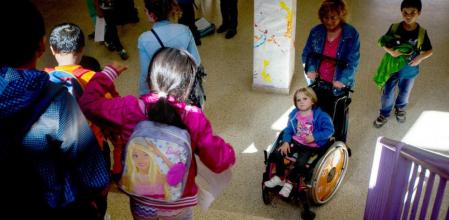 Marina, con su abuela y su hermano, junto a las escaleras que conducen a las aulas del primer piso