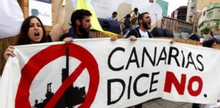 Varias personas protestan con pancartas contra las prospecciones petrolíferas autorizadas por el Ministerio de Medio Ambiente en aguas de Canarias