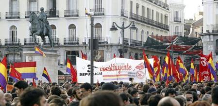 Varias personas portan banderas republicanas durante una concentración celebrada en la Puerta del Sol de Madrid a favor de la República