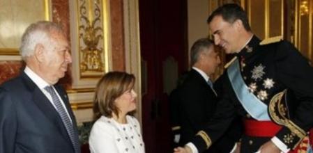 El rey Felipe VI saluda a la vicepresidenta del Gobierno, Soraya Sáenz de Santamaría, en presencia del ministro de Asuntos Exteriores, José Manuel García Margallo (i), tras la ceremonia de proclamación celebrada en el Congreso de los Diputados.