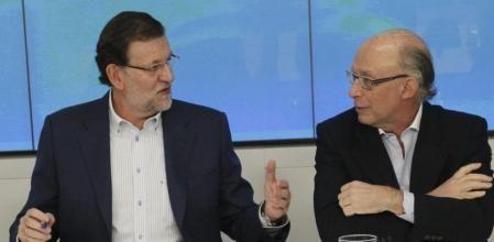 El jefe del Ejecutivo, Mariano Rajoy (i), conversa con el ministro de Hacienda, Cristóbal Montoro, al inicio de la reunión que preside hoy en la sede nacional del partido para explicar la reforma fiscal aprobada ayer por el Consejo de Ministros. EFE/Paco Campos
