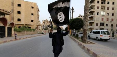 Un miembro del Estado Islámico ondea una bandera tras la instauración del califato en una imagen de archivo