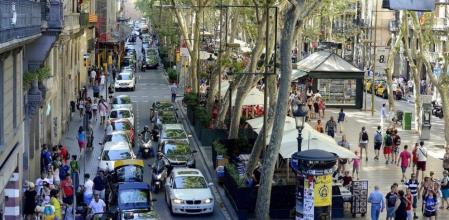 Lateral de la Rambla de bajada con trafico de coches, peatones y terrazas del,paseo central