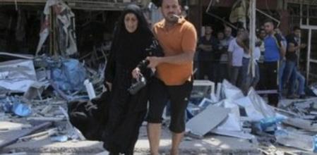 Un hombre ayuda a una mujer tras explotar un coche bomba en Bagdad