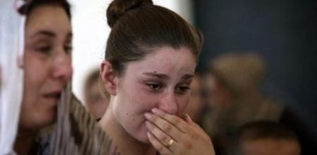 Una refugiada yazidí llora mientras hace cola en una escuela en la que se han refugiado tras huir de el Estado Islámico