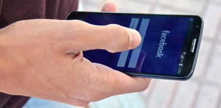 Un joven accede a Facebook desde su 'smartphone'