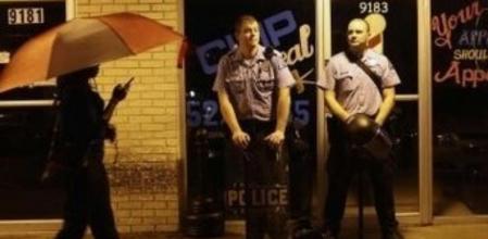 Agentes de policía armados vigilan el toque de queda en Ferguson, en Misuri
