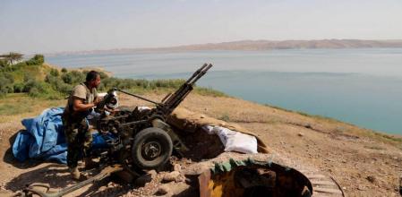 Un combatiente kurdo prepara su arma a su posición de combate cerca de la presa de Mosul