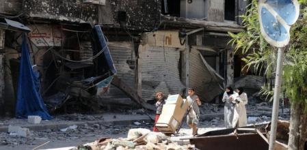 Residentes en el campo de refugiados palestinos de Yarmuk, al sur de Damasco, recolectan comida
